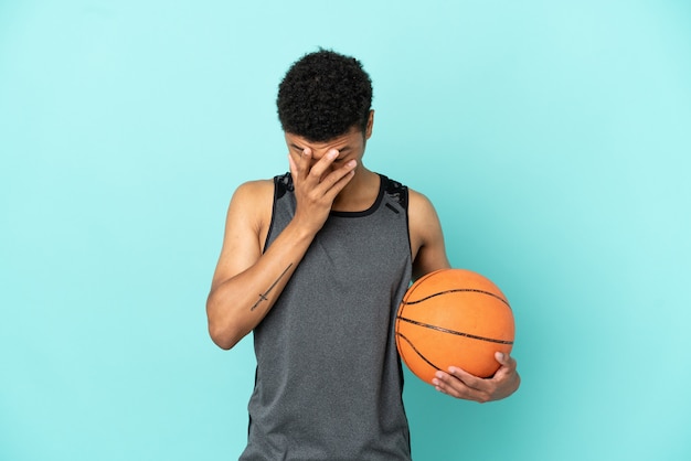 Giocatore di basket afroamericano isolato su sfondo blu con espressione stanca e malata