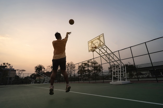 Giocatore di basket che si allena e si esercita all'aperto sul campo locale