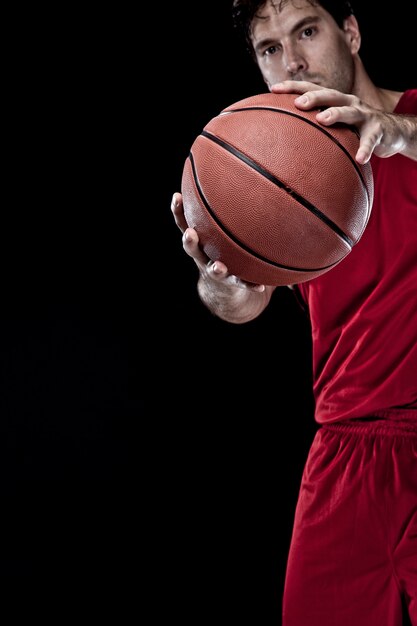 Giocatore di basket con una palla in mano e una divisa rossa.