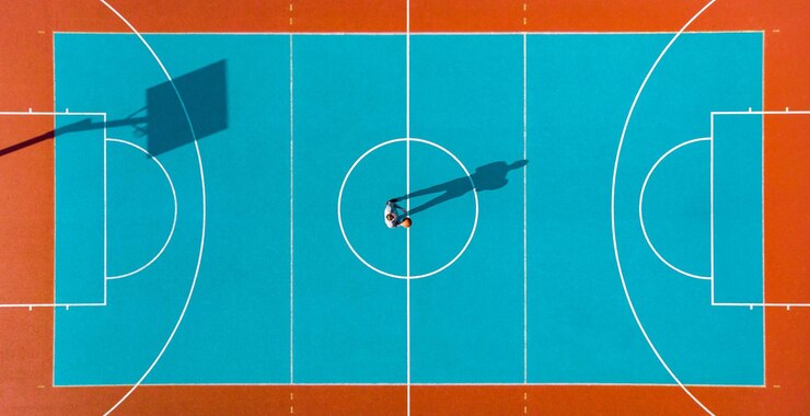 Giocatore di basket ombre lunghe sul campo da basket Creative Visual Art immagine aerea