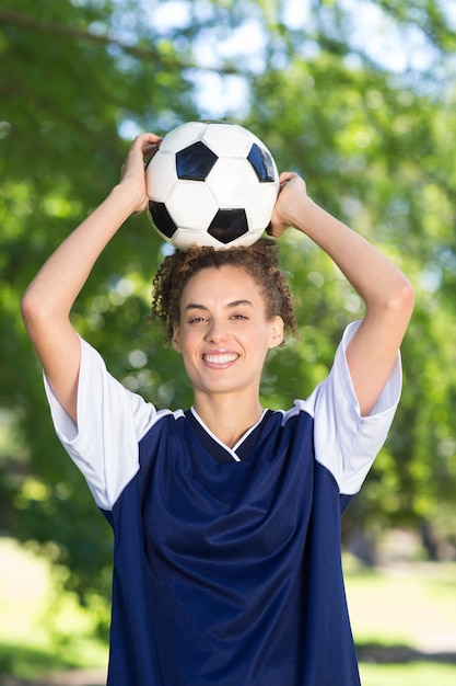 Giocatore di calcio grazioso che sorride alla macchina fotografica