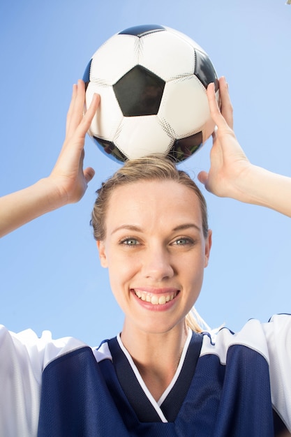 Giocatore di calcio grazioso che sorride alla macchina fotografica