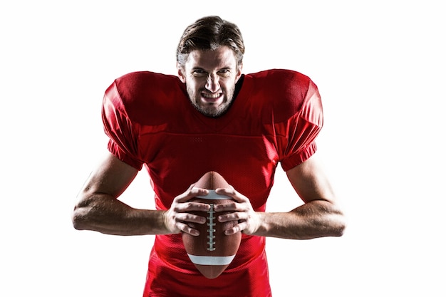 Giocatore di football americano aggressivo in palla rossa che tiene palla