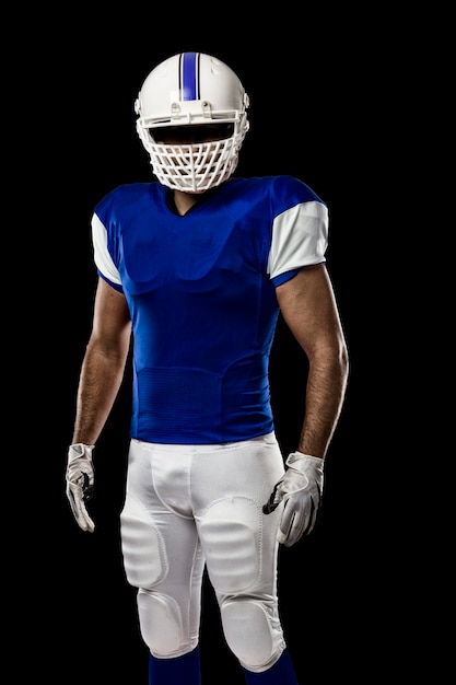 Giocatore di football americano con un'uniforme blu su una parete nera