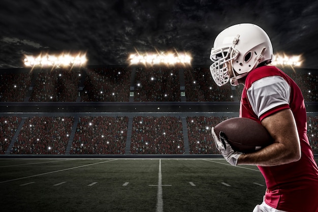 Giocatore di football americano con un'uniforme rossa in esecuzione su uno stadio.