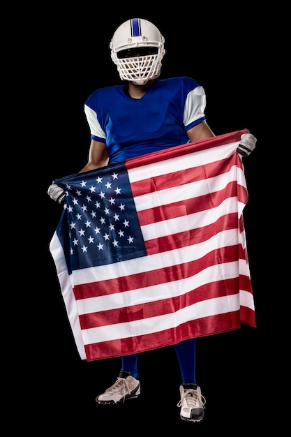Giocatore di football americano con una divisa blu e una bandiera americana, su una parete nera