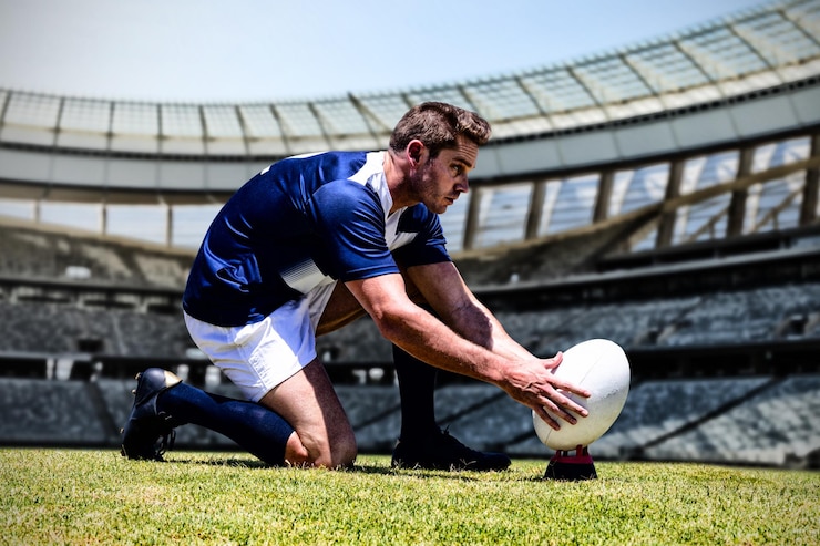 Foto giocatore di football americano contro il palo della porta di rugby in una giornata di sole nello stadio