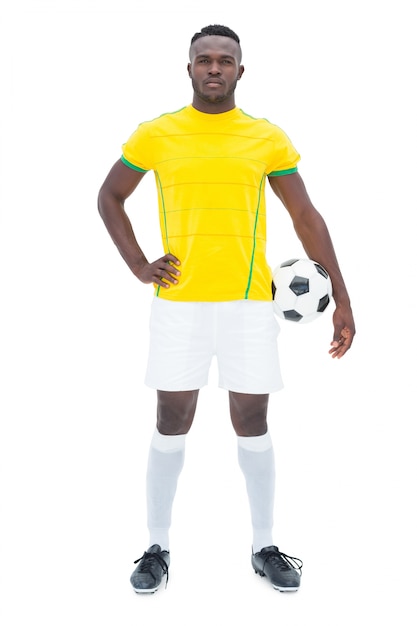 Giocatore di football americano in piedi giallo con la palla