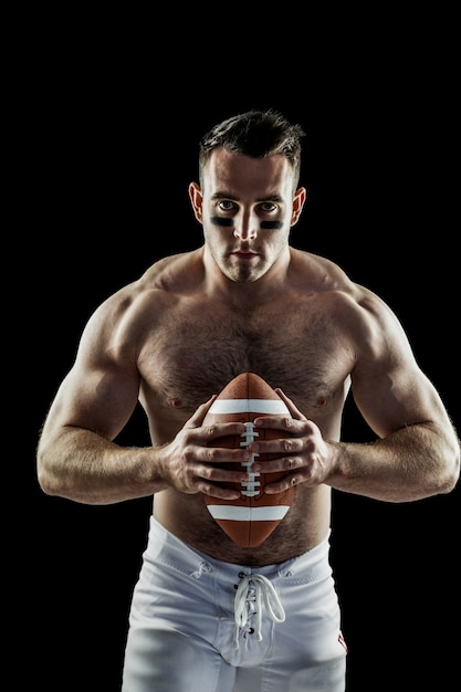 Giocatore di football americano senza camicia con la palla