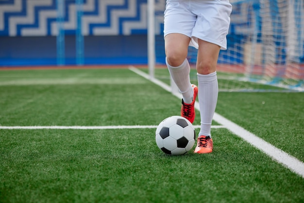 giocatore di football di una ragazza sportiva con un pallone da calcio sul campo di calcio il concetto di calcio femminile professionistico