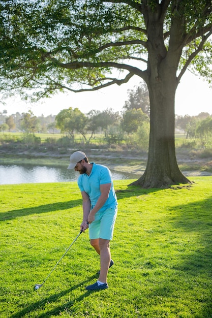 Giocatore di golf che mette la pallina da golf sul golf verde