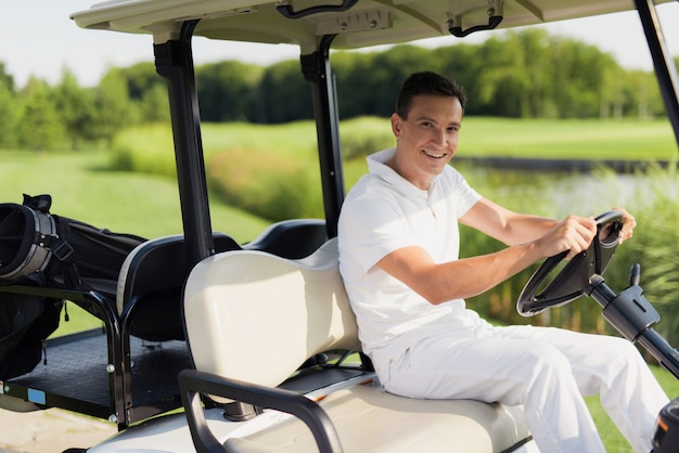 Giocatore di golf felice nella ricreazione attiva di lusso dell&#39;automobile.