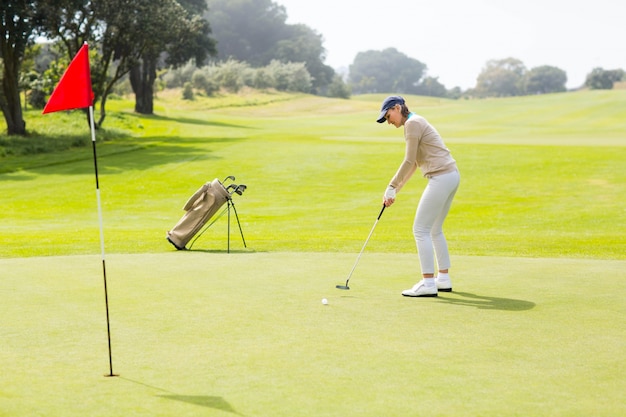 Giocatore di golf femminile che mette la sua palla