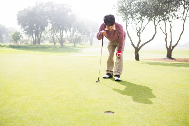 Giocatore di golf guardando il buco