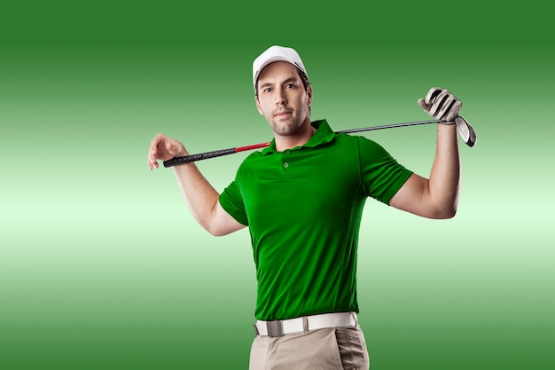 Giocatore di golf in una camicia verde che fa un'altalena, su uno sfondo verde.