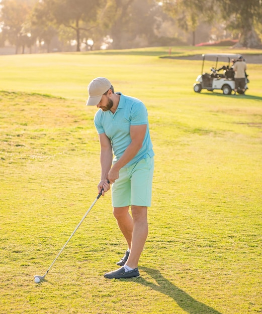 Giocatore di golf maschio sul corso professionale con gli sport di tempo soleggiato dell'erba verde