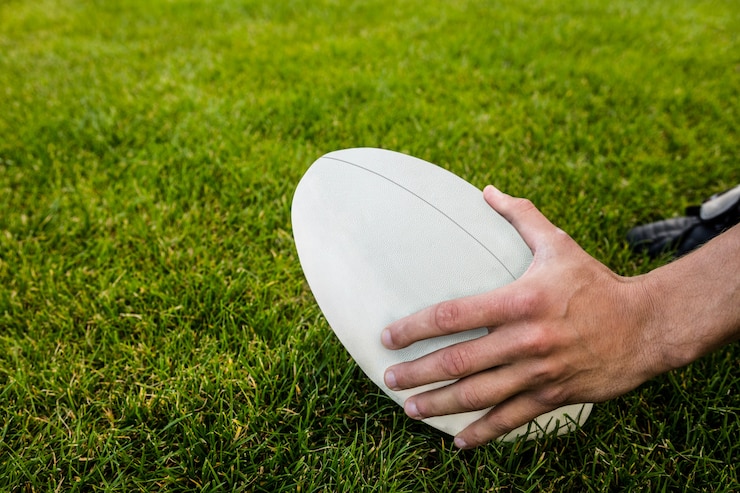 Foto giocatore di rugby che raccoglie palla