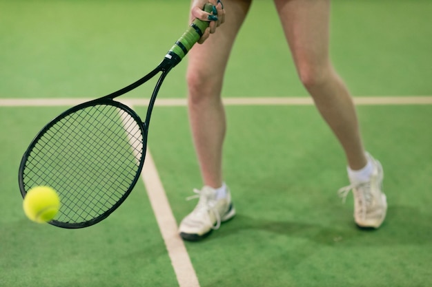 Giocatore di tennis donna che gioca allenamento con racchetta e palla a corte