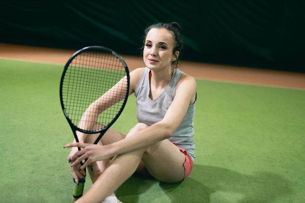 Giocatore di tennis donna che gioca allenamento con racchetta e palla a corte