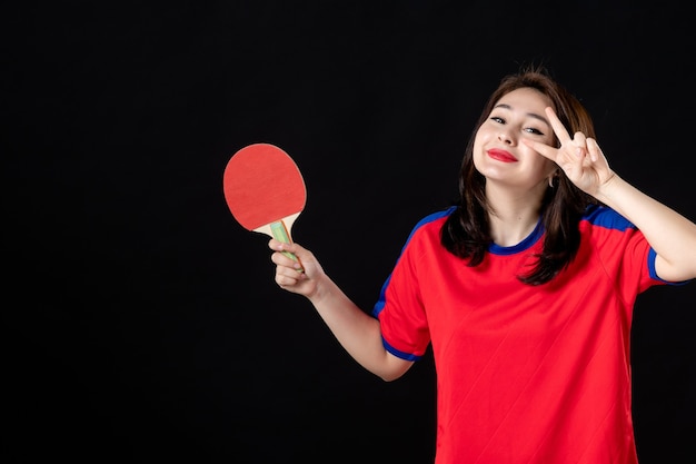 Giocatore di tennis femminile con la racchetta sul buio