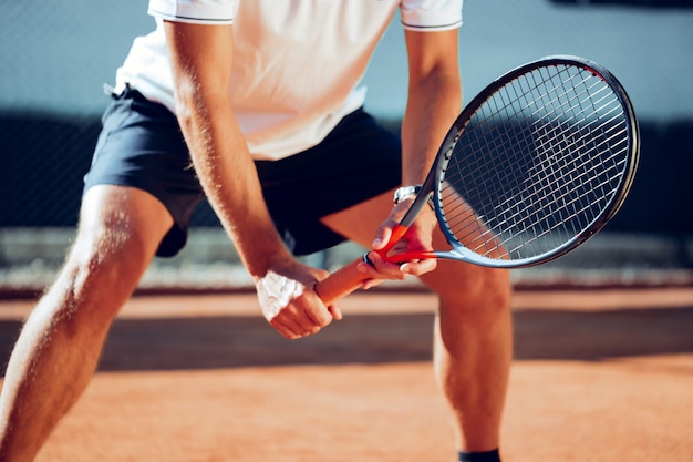 Giocatore di tennis in piedi in posizione pronta sul campo da tennis