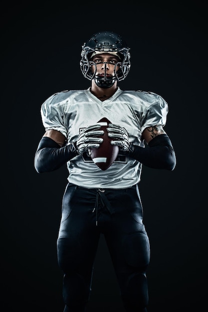 Giocatore sportivo di football americano in casco su sfondo nero Sport e motivazione Sport di squadra