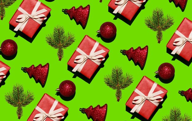 Giocattoli di Natale palle ramo di albero di Natale e un regalo festivo su uno sfondo verde natale seamle...