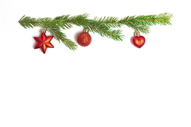 Giocattoli di Natale rosso e rametti di abete rosso su sfondo bianco isolato. Elementi di design.