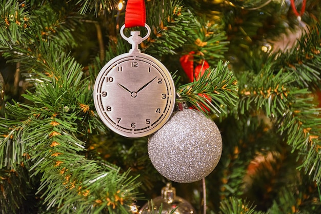 Giocattolo a forma di orologio sul ramo di un albero di Natale