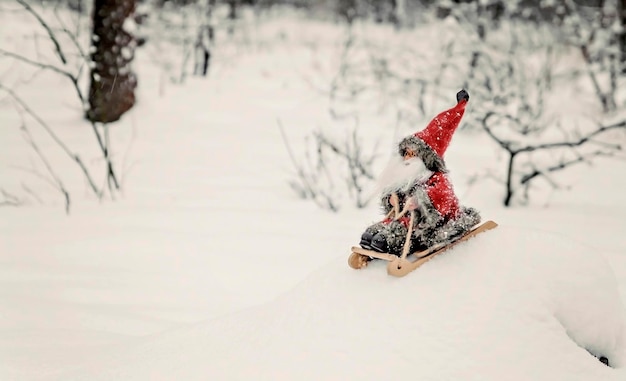 Giocattolo Babbo Natale su una slitta in un bosco innevato