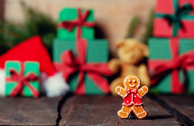 Giocattolo del biscotto dell'uomo di pan di zenzero e scatole regalo di Natale sullo sfondo