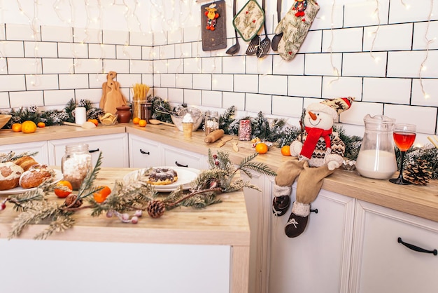 Giocattolo del pupazzo di neve interno della cucina decorata bella di Natale che si siede sulla tavola di legno