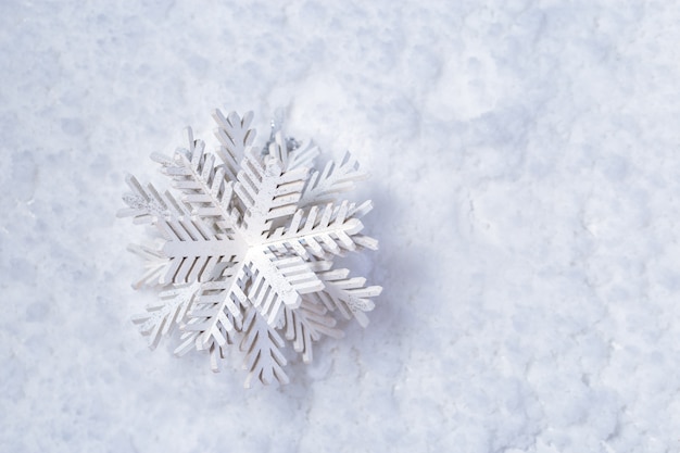 Giocattolo di legno bianco del fiocco di neve su neve