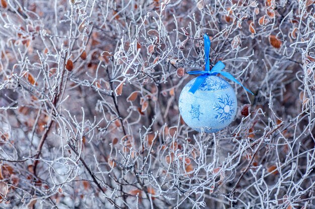 Giocattolo di natale con palla blu su un ramo di un albero di Natale Natale in città Sfondo per il nuovo anno