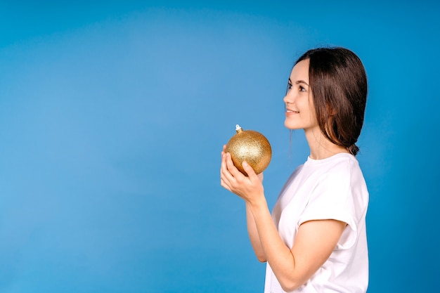 Giocattolo di Natale della stretta della giovane donna isolato sullo sguardo blu della parete