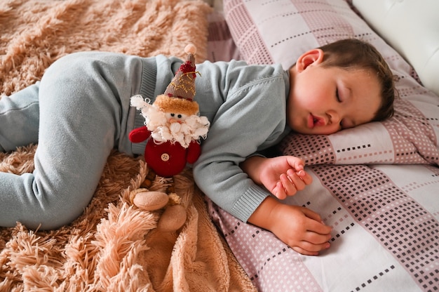Giocattolo di Natale sullo sfondo di un ragazzino addormentato