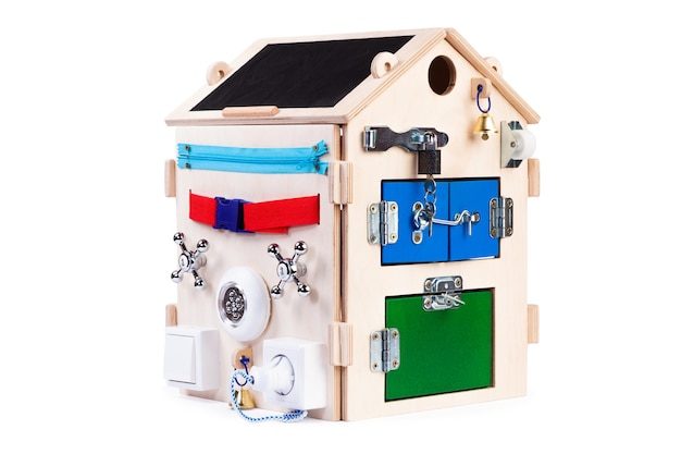 Giocattolo educativo in legno ecofriendly occupato board house per bambini neonati su uno sfondo bianco isolato composto da pezzi di puzzle in legno multicolore labirinto ingranaggi selezionatore interruttori prese miscelatori d'acqua