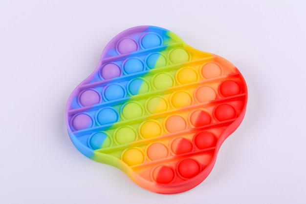 Giocattolo per bambini dai colori vivaci realizzato in silicone progettato per alleviare lo stress su uno sfondo di carta da una tonnellata. fai scoppiare