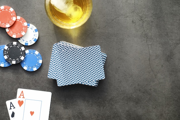 Giochi di carte per soldi. Il poker in versione Texas Holdem. Carte in mano, fiches da gioco, un mazzo di carte alcoliche in un bicchiere.