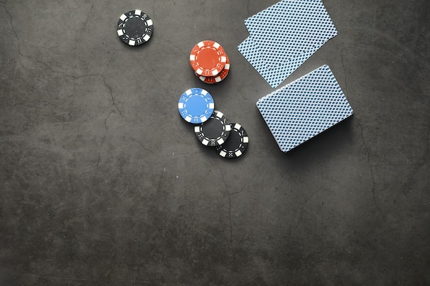 Giochi di carte per soldi. Il poker in versione Texas Holdem. Carte in mano, fiches da gioco, un mazzo di carte alcoliche in un bicchiere.