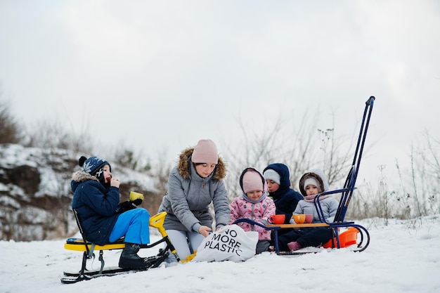 Giochi in famiglia e gite in slitta in inverno all'aperto, i bambini si divertono, bevono tè.