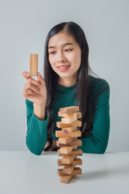 Gioco asiatico della giovane donna di affari con i blocchi di legno