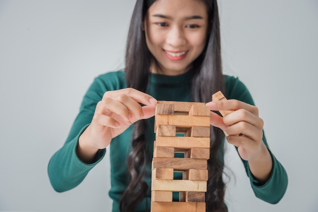 Gioco asiatico della giovane donna di affari con i blocchi di legno