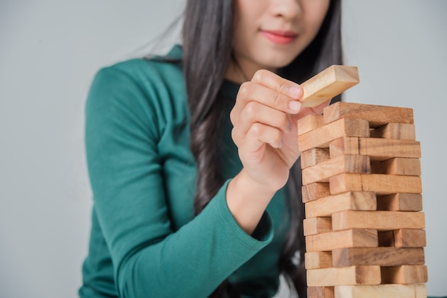Gioco asiatico della giovane donna di affari con i blocchi di legno
