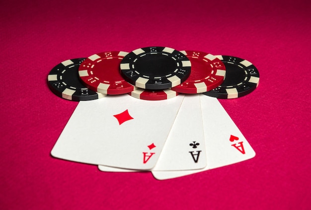 Gioco di poker con una combinazione di tris o set di fiches e carte sul tavolo rosso