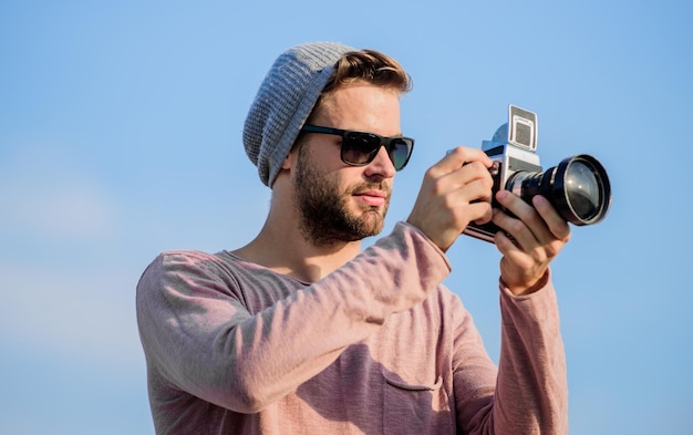 Gioia artistica di catturare il mondo giornalista turistico uomo sexy cattura giornalista d'avventura fotografo in occhiali uomo macho con fotocamera viaggio con fotocamera stile moda maschile alla moda