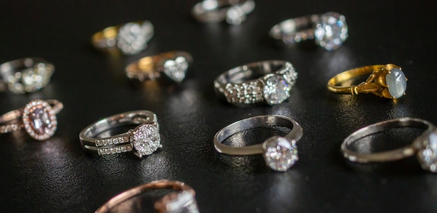 Gioielli anelli di diamanti impostati su sfondo nero da vicino