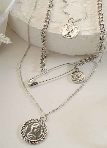 Gioielli di moda - catena tripla in argento con medaglioni su supporto bianco