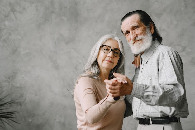 Gioiosa attiva vecchia coppia romantica in pensione che balla in soggiorno.