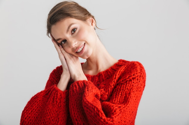 gioiosa bella donna in maglione rosso sorridente e guardando direttamente isolato su sfondo bianco